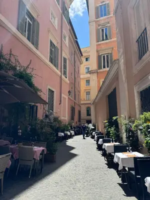 an alley with tables and chairs in an old building at Maison Luxury Pantheon in Rome