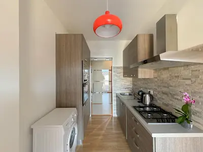 a kitchen with a stove top oven next to a counter at Lumen House - Attico con Suite in Rome