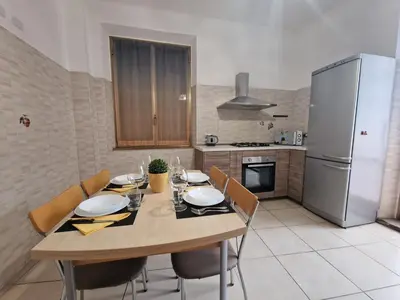 a kitchen with a wooden table with chairs and a refrigerator at GarbantSuite Apartment In Rome in Rome