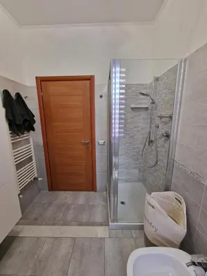 a bathroom with a shower and a toilet and a door at GarbantSuite Apartment In Rome in Rome