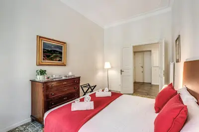 a bedroom with a large bed with red pillows at Nest House Prati in Rome