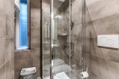 a shower with a glass door in a bathroom at Nest House Prati in Rome