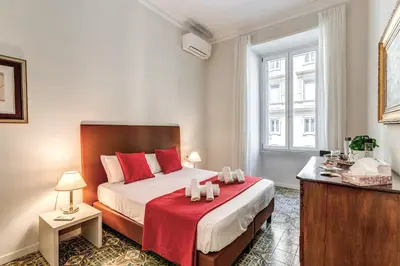 a bedroom with a large bed with red pillows at Nest House Prati in Rome