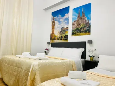 a bedroom with two beds and a painting on the wall at Rome Holiday Guesthouse in Rome