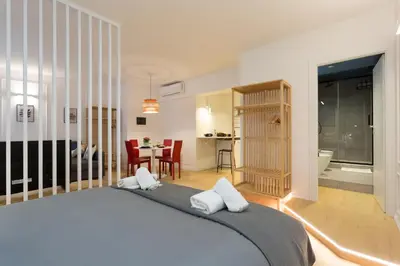 a bedroom with a large bed and a dining room at Panti Guesthouse in Rome