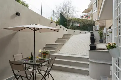 a patio with a table with an umbrella and stairs at Panti Guesthouse in Rome