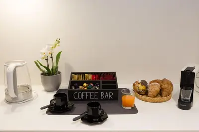 a coffee bar with a book and a basket of bread at Panti Guesthouse in Rome