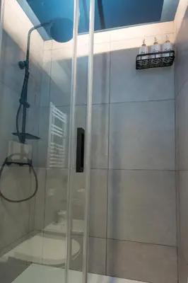 a shower with a glass door in a bathroom at Panti Guesthouse in Rome