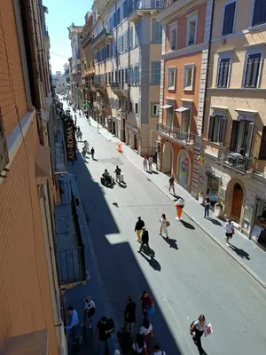 a group of people riding skateboards down a street at Rooms house corso 22 in Rome