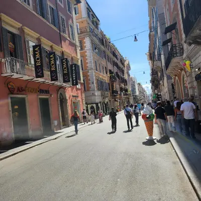 a group of people riding skateboards down a city street at Rooms house corso 22 in Rome