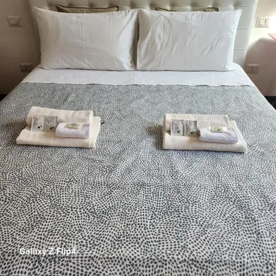 a bedroom with a bed with towels on it at Rooms house corso 22 in Rome