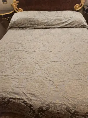 a bed with a white comforter on top of it at Rooms house corso 22 in Rome