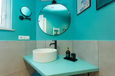 a bathroom sink with a mirror on a blue wall at Filo Guesthouse in Rome
