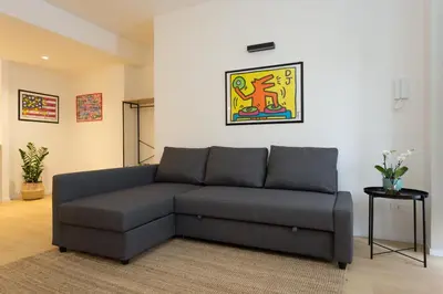 a living room with a gray couch in a room at Filo Guesthouse in Rome