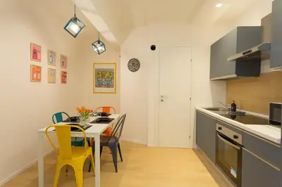 a kitchen with a dining table and yellow chairs at Filo Guesthouse in Rome