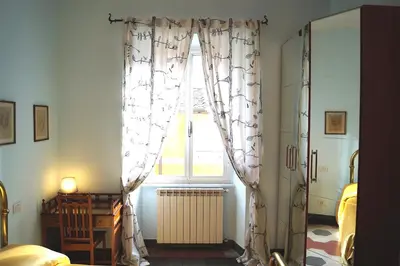 a bedroom with a window with curtains and a radiator at Holidays Banchi Vecchi Apartment in Rome