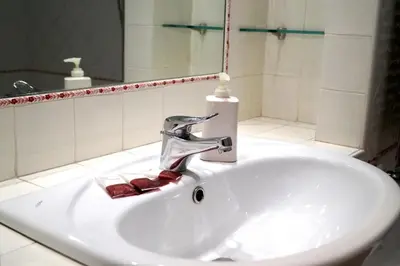 a sink in a bathroom with a faucet at Holidays Banchi Vecchi Apartment in Rome