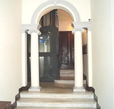 a hallway with a black door and two white columns at Holidays Banchi Vecchi Apartment in Rome