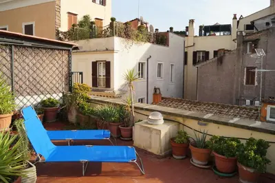 two blue chairs on a balcony with plants at Holidays Banchi Vecchi Apartment in Rome