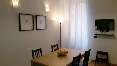 a dining room with a table with chairs and a television at LCH-Lateran Charming House in Rome