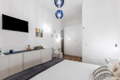a white bedroom with a bed and a flat screen tv at Casa Crispi by Hili in Rome