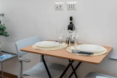 a table with two white plates and a bottle of wine at Casa Crispi by Hili in Rome