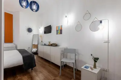 a white bedroom with a bed and a chair at Casa Crispi by Hili in Rome
