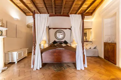a bed in a room with a canopy bed with a lamp at Navona Historic Lovely Flat in Rome