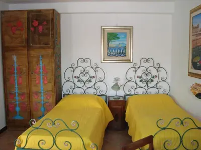 two beds in a room with yellow sheets at Terrazza di Antonio in Rome