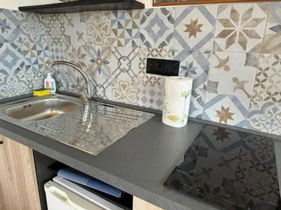 a kitchen counter with a sink and a tile wall at Terrazza di Antonio in Rome