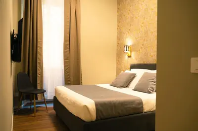 a hotel room with a bed and a chair at Casa Del Grande in Trastevere in Rome
