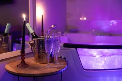 a table with two wine glasses and a candle at City Vibe Red Rose in Rome
