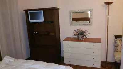 a bedroom with a bed and a dresser with a television at Casa Lory in Rome