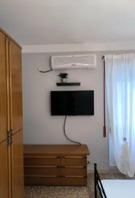 a living room with a tv and a dresser with a tvicterictericter at Bilocale in Via degli Orti Variani in Rome