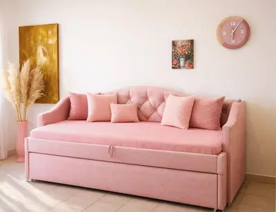 a pink couch in a living room with a clock at Colosseum window 1800-Romantic apartment Rome in Rome