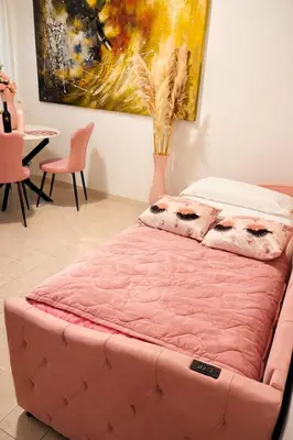 a pink tufted bed in a room with a painting at Colosseum window 1800-Romantic apartment Rome in Rome