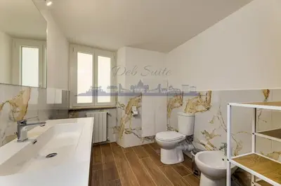 a white bathroom with a toilet and a sink at DEB Suite Campo de' fiori nel cuore di Roma in Rome