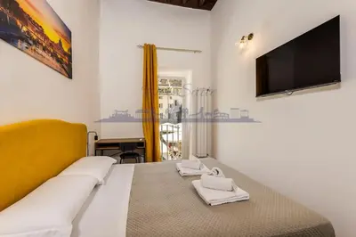 a bedroom with a bed with a tv on the wall at DEB Suite Campo de' fiori nel cuore di Roma in Rome