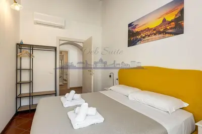 a bedroom with a large bed with two towels at DEB Suite Campo de' fiori nel cuore di Roma in Rome