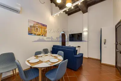 a dining room with a table and blue chairs at DEB Suite Campo de' fiori nel cuore di Roma in Rome