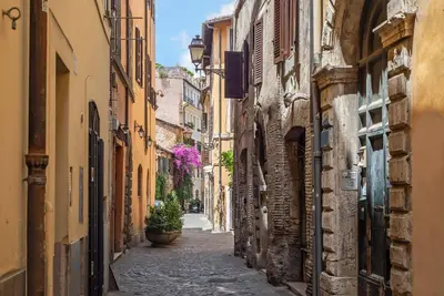 an alley in an old town with flowers at Essence Guesthouse in Rome