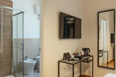 a bathroom with a sink and a toilet and a mirror at Essence Guesthouse in Rome