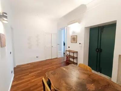 a dining room with a table and a green door at Casa Lucrezia in Rome
