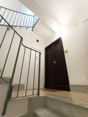 a black door in a white room with stairs at Casa Lucrezia in Rome