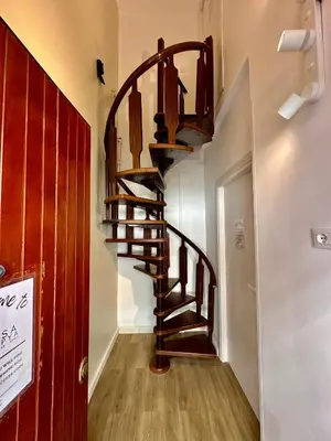 a wooden spiral staircase in a hallway with a door at Casa Happya - Metro A - Central Rome in Rome