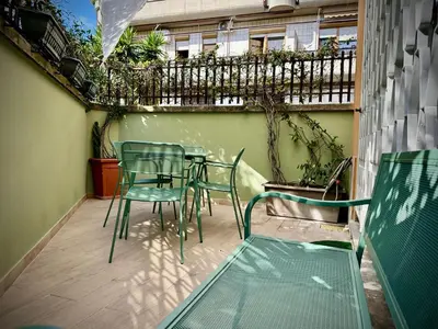 a patio with chairs and tables on a balcony at Casa Happya - Metro A - Central Rome in Rome