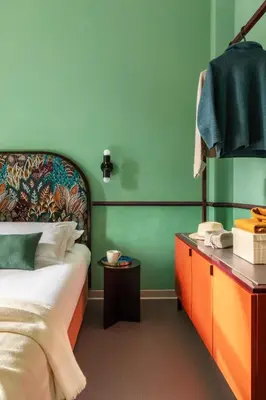 a bedroom with a bed and a mirror and a purple chair at Barberini Retreat Boutique Hotel in Rome