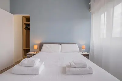 a bedroom with a large white bed with two towels at BBB House Saint Peter in Rome