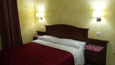 a bedroom with a bed with red sheets and white pillows at Pitagora House in Rome