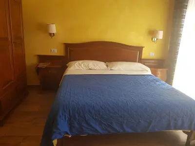 a bedroom with a bed with a blue bedspread and white pillows at Pitagora House in Rome